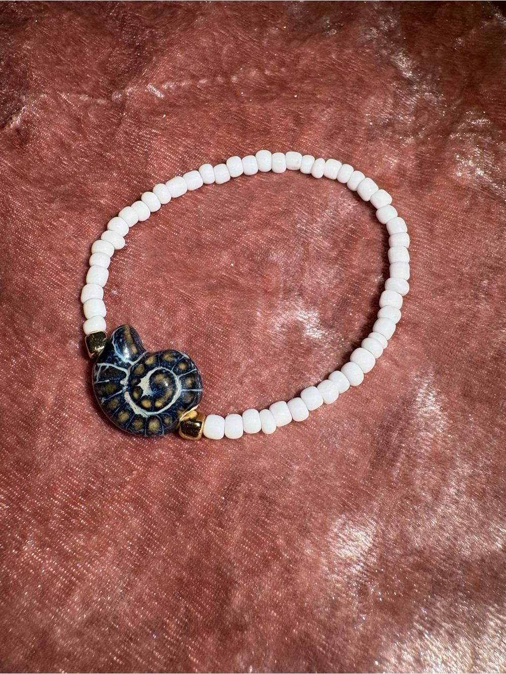 White Beaded Bracelet with Blue Spiral Shell Accent